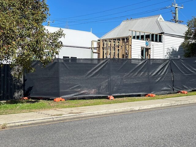 A building that has been covered with tarps.