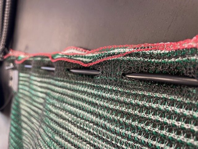 A close up of the fabric with metal pins.